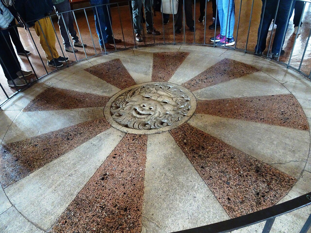 A circular marble floor with a carved mask at its centre inside a Palladian villa