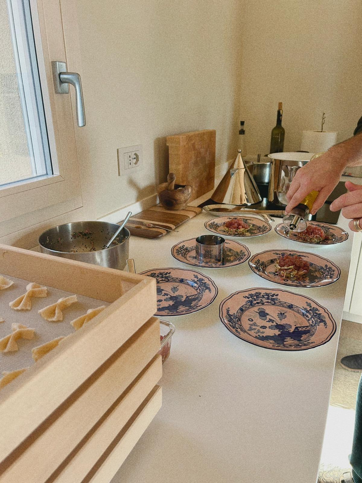 Hand-made pasta on a tray and antique blue and white plates being served in a home kitchen